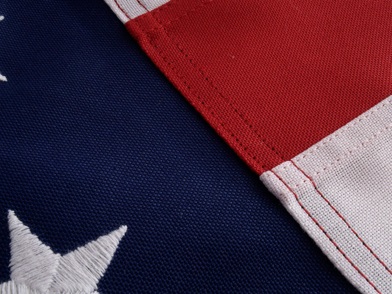 Load image into Gallery viewer, Closeup shot of both the starfield and stripes of a polyester US flag, showcasing the intricate details of the stitching and embroidering.