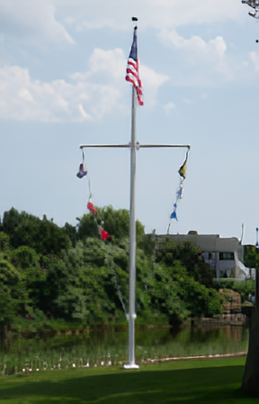 Load image into Gallery viewer, Fiberglass external hinge base flagpole with yardarm installed near a lake, flying the American flag and nautical signal flags.