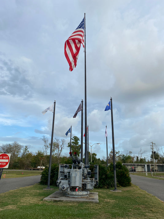 An 80-foot aluminum flagpole with an external halyard system, displaying a large American flag at the top.