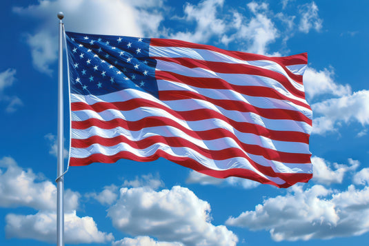 American flag waving against a blue sky with white clouds