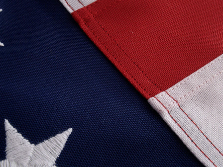 Closeup shot of both the starfield and stripes of a polyester US flag, showcasing the intricate details of the stitching and embroidering.