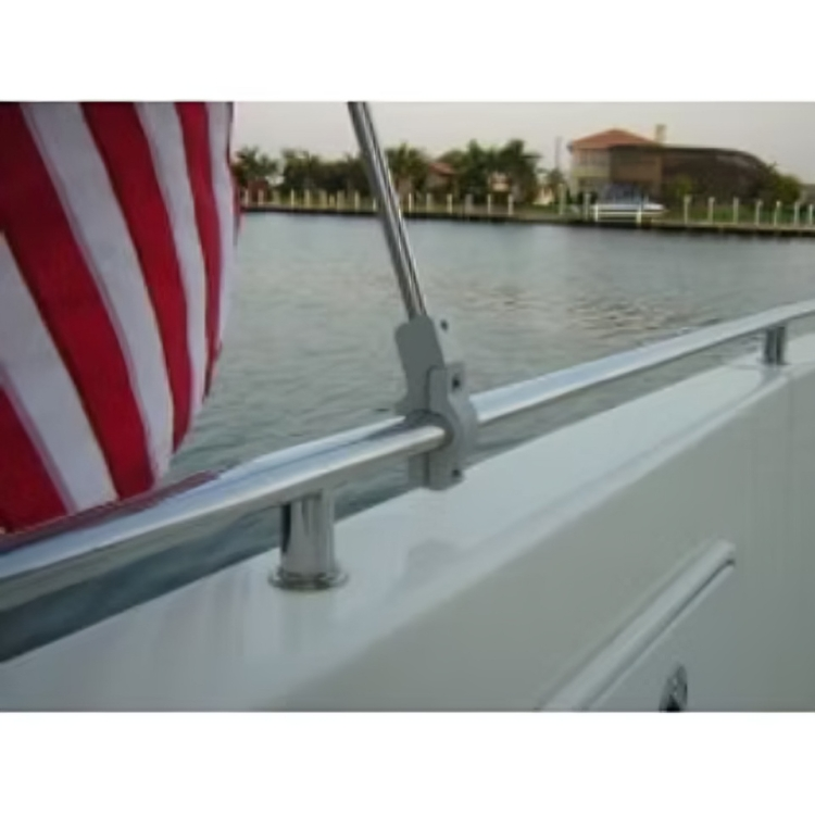 Custom oval swiveler boat flagpole rail clamp installed on a boat's chrome railing, securely holding a flagpole displaying a folded American flag over the water.