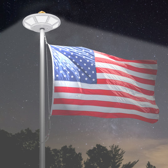 Elite Solar Flagpole Disk Light illuminating an American flag at night, providing bright, even coverage under starry skies.
