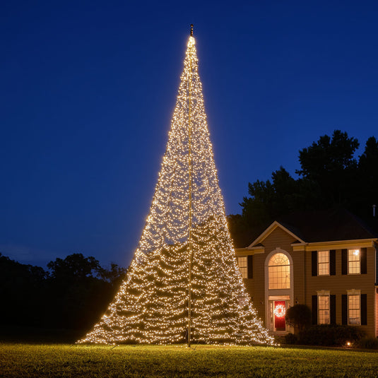 Large outdoor Fairybell Flagpole Christmas Tree Light displayed in full warm white against a dark blue evening sky.