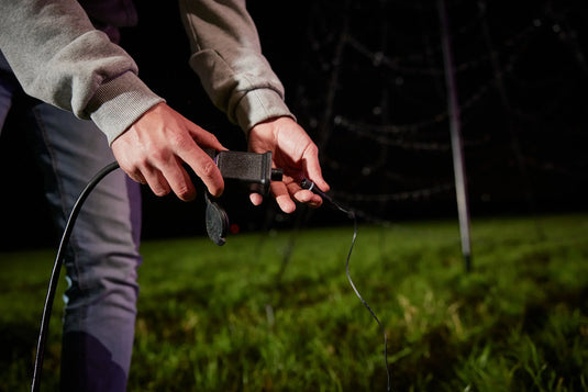 Hands twisting the specialized dual-color plug, which features the Luminous Switch technology for the Fairybell Flagpole Christmas Tree Light.
