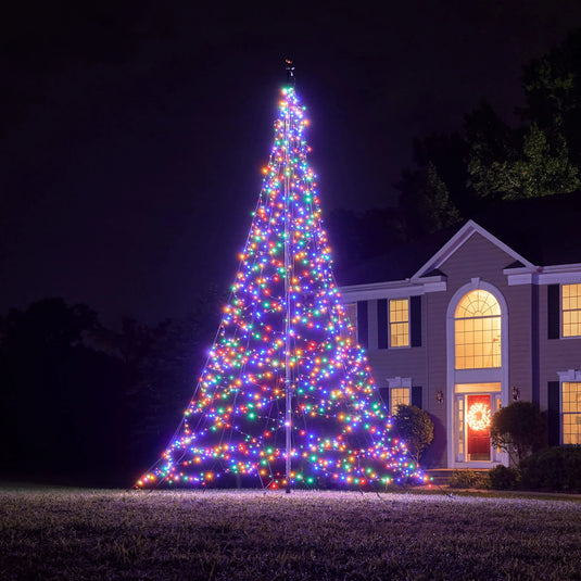 Fairybell Multi-Color Flagpole Christmas Tree Light illuminating the front of a house at night with festive holiday cheer.