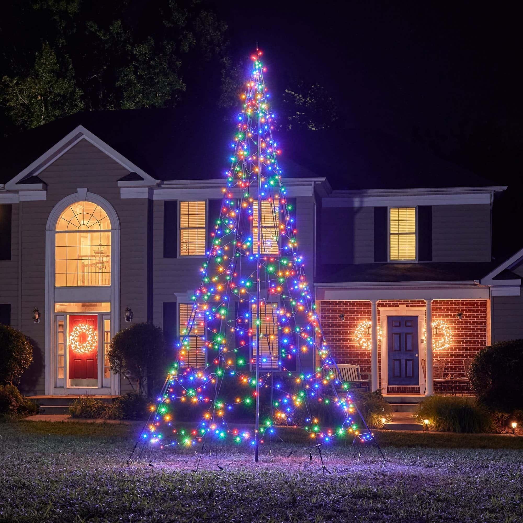 Fairybell Multi-Color Flagpole Christmas Tree Light in a residential yard highlighting the pole structure and colorful LED strings.