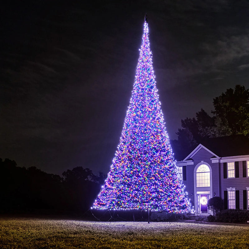 Load image into Gallery viewer, Tall, brightly lit Fairybell Multi-Color Flagpole Christmas Tree Light providing wide-angle illumination to a residential landscape at night.
