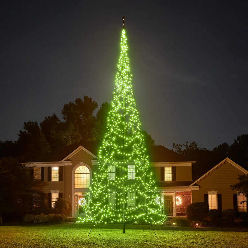 Load image into Gallery viewer, Tall outdoor Fairybell Single Color Flagpole Christmas Tree Light fully illuminated in bright green against a dark sky.
