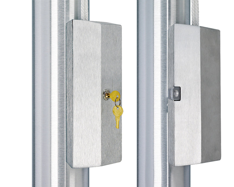 Load image into Gallery viewer, Two Flagpole Cleat Cover Boxes mounted side-by-side on brushed aluminum flagpoles. The cleat cover on the left is locked with a key inserted, while the cover on the right shows the square keyhole, emphasizing the anti-theft security feature.
