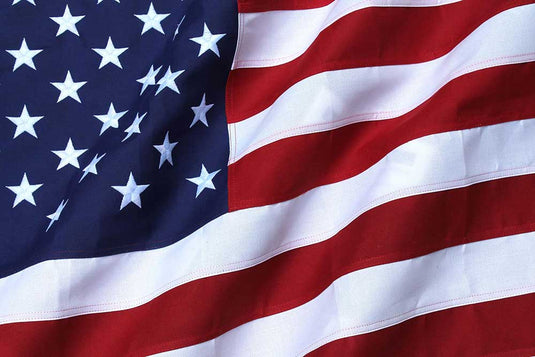 Close-up view of an American flag made of heavy-duty polyester, showing detailed stripes and stars.