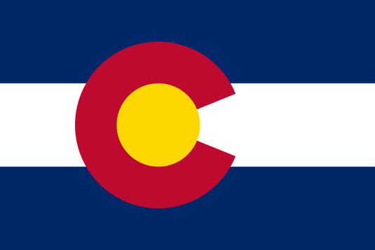 High-quality ceremonial Indoor Flag of Colorado with horizontal navy blue and white stripes. The flag is dominated by the bold, centered crimson "C" and golden sun disc emblem, representing the state's mountains, sunlight, and colored earth.