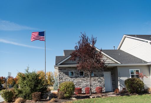 Load image into Gallery viewer, Silver Titan Telescoping Flagpole Kit flying the American flag high above a residential home on a sunny day.
