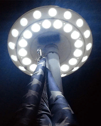 Load image into Gallery viewer, Solar Disk light on top of flag pole, illuminated, viewed from below.
