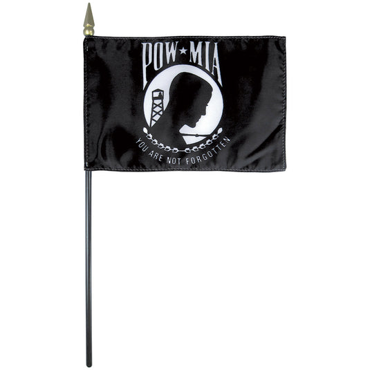 A rectangular black flag with the text 'POW-MIA' and an emblem that includes a soldier's silhouette. It is mounted on a stick for display.