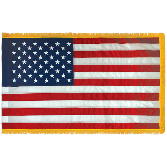 An American flag with gold fringe displayed on a white background.